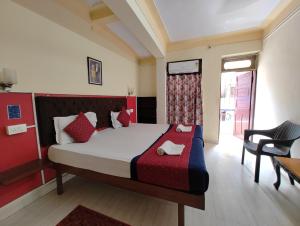 ein Schlafzimmer mit einem Bett, einem Stuhl und einem Fenster in der Unterkunft Sanman Hotels in Vasco Da Gama