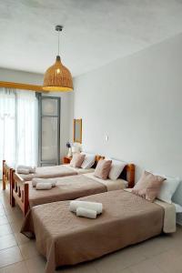 Un grupo de 4 camas en una habitación en VIRI VIRI APARTMENTS en Lilikás