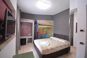 1 dormitorio con 1 cama y una ventana con flores en Suite Manzoni, en Boffalora sopra Ticino