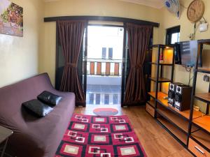 a living room with a couch and a large window at Villa Dengan Kolam Renang di Malang in Malang