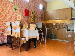 eine Küche mit einem Tisch und einer Ziegelwand in der Unterkunft Villa Dengan Kolam Renang di Malang in Malang