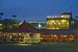 a group of people standing outside of a building at night at Villa Dengan Kolam Renang di Malang in Malang