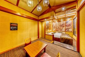 Habitación con cama y mesa de madera. en Hotel Liebhaber -Adult Only, en Hirakata