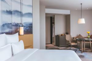 um quarto de hotel com uma cama e uma mesa em Pullman Fuzhou Tahoe em Fucheu