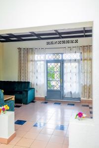 Rhoja homes في روهينجيري: غرفة معيشة مع أريكة وباب