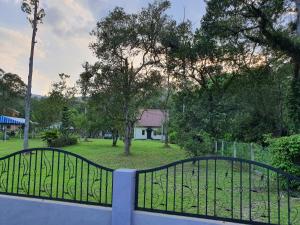 a fence in front of a park with a house at Teratak D Tuntung in Kampong Mesjid