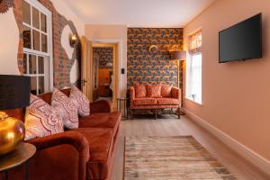 uma sala de estar com um sofá e uma televisão em Apartments at Number 16 - The Jolly Coopers em Hampton