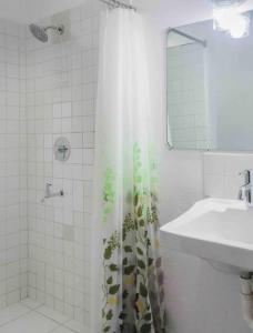 a bathroom with a sink and a shower curtain at Oceans Rental Apartments in DʼArbeau