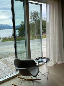 a black chair and a table in front of a window at Villa Northern Light in Tromsø