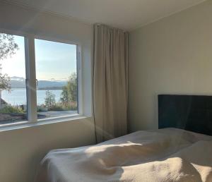 a bedroom with a bed and a large window at Villa Northern Light in Tromsø