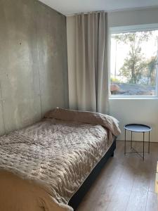 a bed in a bedroom with a window and a table at Villa Northern Light in Tromsø +9 photos