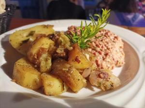 einen Teller mit Kartoffeln und Fleisch auf dem Tisch in der Unterkunft Domaine Le Clos du Figuier Spa in Verdun-sur-Garonne