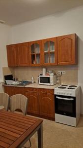 Il comprend une cuisine équipée d'une cuisinière et d'un four micro-ondes. dans l'établissement Charm Apartment, à Kecskemét