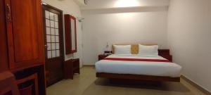 ein Schlafzimmer mit einem großen weißen Bett in einem Zimmer in der Unterkunft Thenmala Ecoresort - The First and the Best in Punalūr
