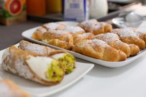 a table with two plates of pastries and donuts at BMode in Catania
