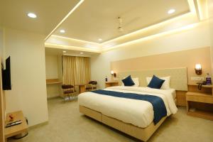a hotel room with a bed and a desk at Hotel 6 Seasons, Koregoan Park, Pune in Pune