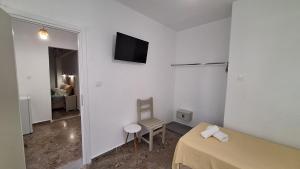 1 dormitorio con 1 cama y TV en la pared en Evita's Resort en Poros