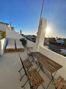 a balcony with two chairs and a table and benches at Villa Calma 450m from the beach in Cala en Blanes