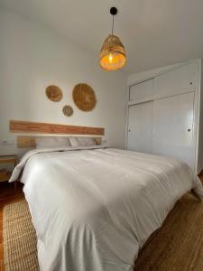 a bedroom with a large white bed and a light at Villa Calma 450m from the beach in Cala en Blanes +20 photos
