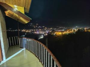 a balcony with a view of a city at night at A Star Regency Hotel Manali near Mall Road in Manāli +178 photos