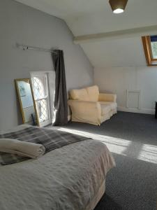 a bedroom with a bed and a couch at Singleton Short Stay Basic Loft Rooms in Swansea