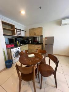a kitchen with a wooden table and chairs at Timurbay Seafront Residences by Nature Home in Kuantan