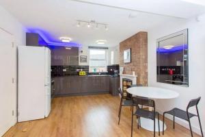 a kitchen with a table and chairs in a room at Сharming & Peaceful 3BDR flat near Wembley station in London