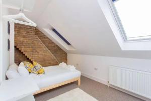 een kamer met een bed en een bakstenen muur bij Сharming & Peaceful 3BDR flat near Wembley station in Londen