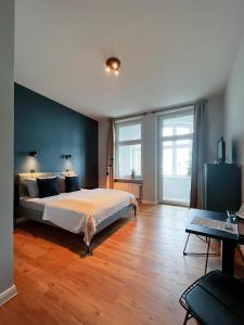 een slaapkamer met een bed met een blauwe muur bij Apartments am Hafen in Stralsund