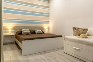 a bedroom with a bed and a striped wall at Casa Le Sorelle in Giardini Naxos