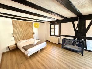 um quarto com uma cama num quarto com pisos em madeira em Gîte "L'Escale du Vignoble" à Ribeauville em Ribeauvillé