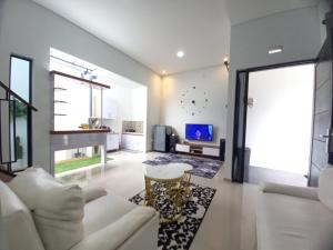 a living room with a white couch and a tv at Villa Estetis di Kota Batu in Malang