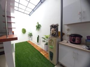 kuchnia z zielonym dywanem w środku pokoju w obiekcie Villa Estetis di Kota Batu w mieście Malang