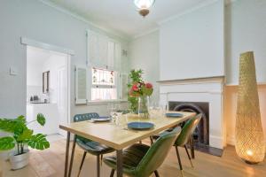 una sala da pranzo con tavolo, sedie e camino di 2 Bedroom House with 2 E-Bikes Included at Centre of Chippendale a Sydney