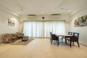 a living room with a table and chairs and a couch at Freesia Residency By Express Inn - Navi Mumbai in Navi Mumbai