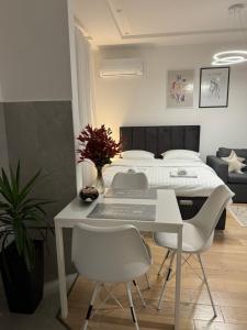 - une chambre avec un lit, une table et des chaises dans l'établissement Apartman PORTO, à Trebinje