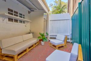 a porch with a couch and a chair on a patio at 2 Bedroom House with 2 E-Bikes Included at Centre of Chippendale in Sydney