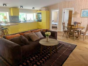 ein Wohnzimmer mit einem braunen Sofa und einem Tisch in der Unterkunft Pušyno apartamentai in Druskininkai