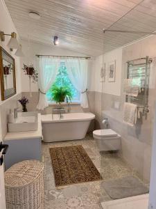 ein Badezimmer mit einer Badewanne, einem WC und einem Waschbecken in der Unterkunft Pušyno apartamentai in Druskininkai