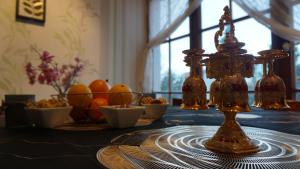 una mesa con varias botellas de vidrio y cuencos de fruta en Darkwolf House, en Merseburgo
