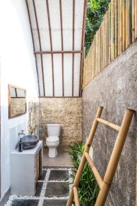 łazienka z toaletą i umywalką w obiekcie Villa Bagus w Gili Air