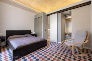 a bedroom with a bed and a chair at Real Tenuta Apartments By Domus Sicily in Palermo