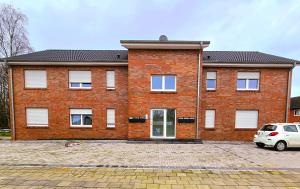 a brick building with a car parked in front of it at EcoCube 443 - Familie, 2Zimmer, 3Betten, Schlafsofa, Backofen, TV, 6Pers in Meppen