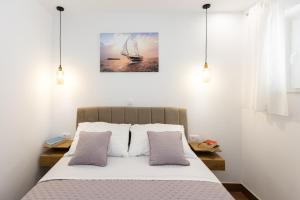 1 dormitorio con 1 cama y una pintura en la pared en Apartment Flora, en Dubrovnik