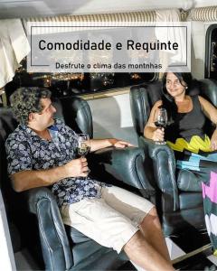 a man and a woman sitting in a chair with wine at Motorhome Mundo em Família in São Roque