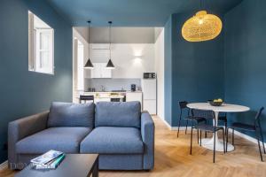 a living room with a blue couch and a table at Real Tenuta Apartments By Domus Sicily in Palermo
