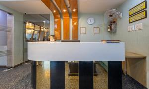 a white counter in a room with a clock on the wall at Treebo Trend Shakuntalam in Lucknow