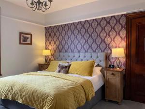 a bedroom with a king sized bed with a purple wall at Overdale Room Only and Free Parking in Whitby