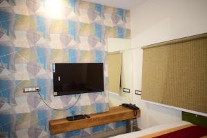 a bathroom with a tv on a wall at Hotel Signor in Indore