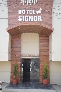 un panneau d'hôtel à l'avant d'un bâtiment dans l'établissement Hotel Signor, à Indore